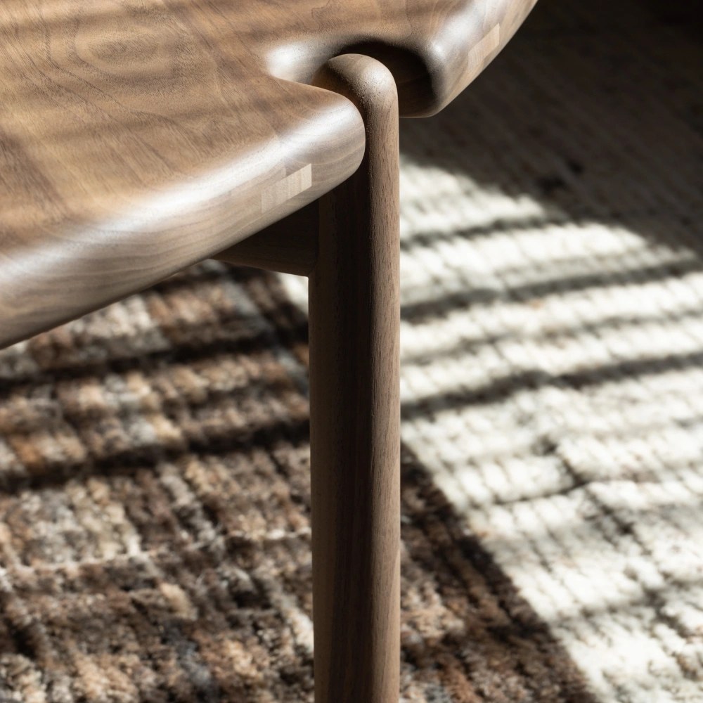Walnut table edge and leg on a hand-knotted rug